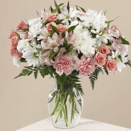 Pink roses and white daisies arranged in a clear glass vase