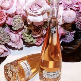 Pink roses with a rosé wine bottle and glass on a table