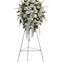 White funeral spray on a metal easel with ribbon