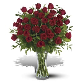Large bouquet of long-stemmed red roses in a tall clear glass vase