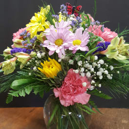 Mixed bouquet in a glass vase with daisies, carnations, and lilies