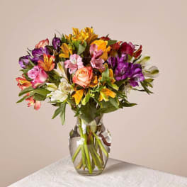 Mixed bouquet of colorful flowers in a clear glass vase
