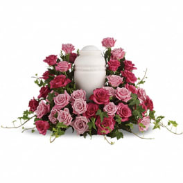 Pink and magenta roses arranged around a white urn