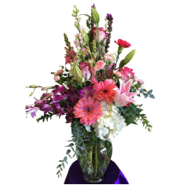 Tall mixed bouquet in a glass vase with pink, purple, and white flowers