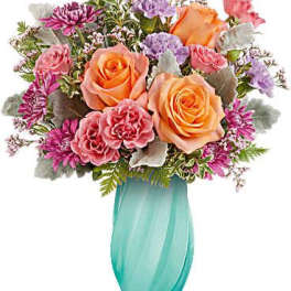 Bouquet of peach and pink roses in a turquoise vase