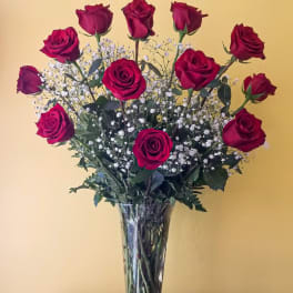Tall vase arrangement of red roses with white baby's breath