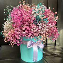 Pink and white baby's breath in a turquoise hatbox with a lavender ribbon