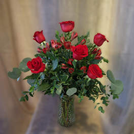 Red roses and red alstroemeria in a clear glass vase