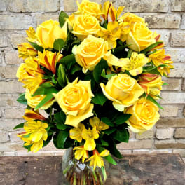 Yellow roses and yellow alstroemeria in a glass vase