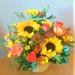 Mixed bouquet with sunflowers, roses, and daisies in a vase