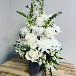 White floral arrangement in a ribbed metal vase