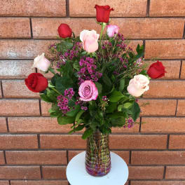 Bouquet of red, pink, and white roses in a glass vase
