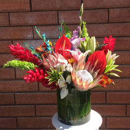 Bright tropical bouquet in a green glass vase