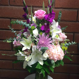 Mixed bouquet in a glass vase with pink, white, and purple flowers