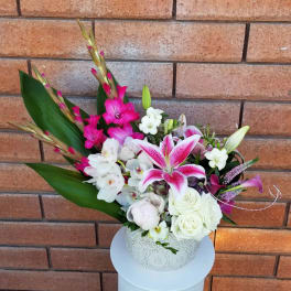 Pink lilies and white roses in a decorative white vase
