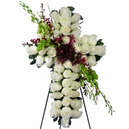 White rose cross arrangement with burgundy and green accents on a stand