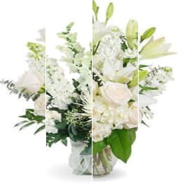 White floral arrangement in a glass vase with lilies and roses