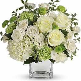 White roses and green pompons in a clear square vase