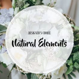White floral arrangement with a round "Designer’s Choice Natural Elements" sign