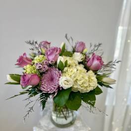 Pink roses and lavender blooms in a glass vase