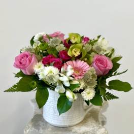 Pink and white mixed flower arrangement in a white vase
