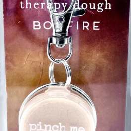Keychain with a round beige charm on a printed card