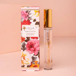 Floral-print perfume box beside a clear glass perfume bottle with a gold cap