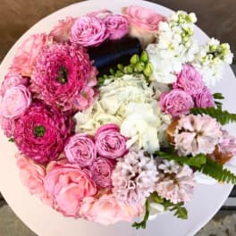 Round bouquet of pink and white flowers on a white surface