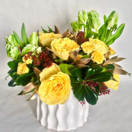 Yellow roses and green tulips in a white vase