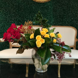 Red and yellow roses arranged in a clear glass vase