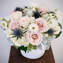 Blush and white rose arrangement in a white vase