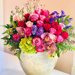 Mixed pink and purple floral arrangement in a silver vase