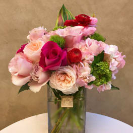 Pink and red rose bouquet in a square glass vase