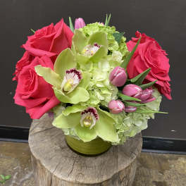 Pink roses and green orchids in a low vase arrangement