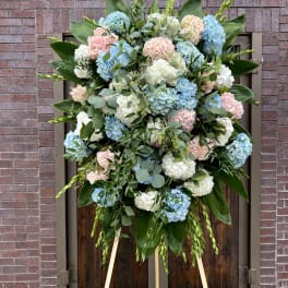 Large standing spray of blue, white, and pink hydrangeas