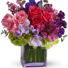 Bouquet of pink and purple flowers in a purple glass vase