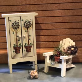 Decorative arrangement with a small potted floral display and rustic chair accents