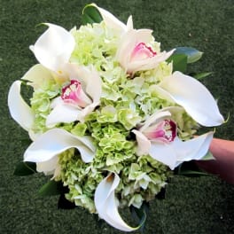 White calla lilies and pale green hydrangeas in a hand-held bouquet