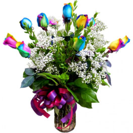 Bouquet of rainbow-colored roses with baby's breath in a glass vase