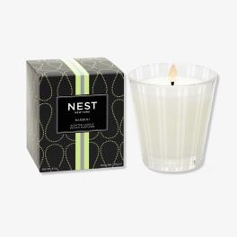 Scented candle in a glass holder beside its box