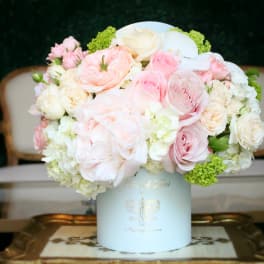 Pastel pink and white rose arrangement in a white hat box
