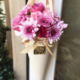 Pink rose and chrysanthemum bouquet wrapped in cream paper with ribbon