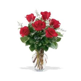 Red roses arranged in a clear glass vase