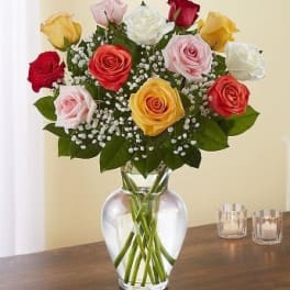 Mixed roses in a clear glass vase with baby's breath
