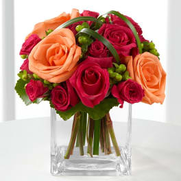 Bouquet of pink and peach roses in a clear glass vase