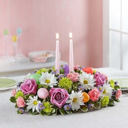 Low floral centerpiece with two pink candles and pastel flowers