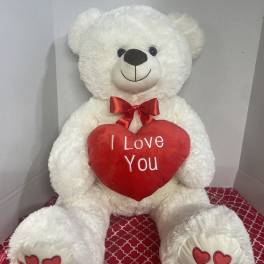 White teddy bear holding a red heart that says I Love You