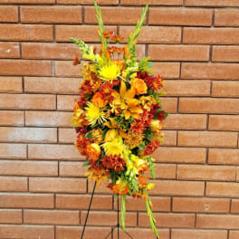Tall orange and yellow floral standing spray on an easel
