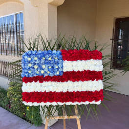 Floral arrangement shaped like the U.S. flag on an easel