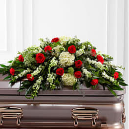 Red roses and white flowers arranged on a casket